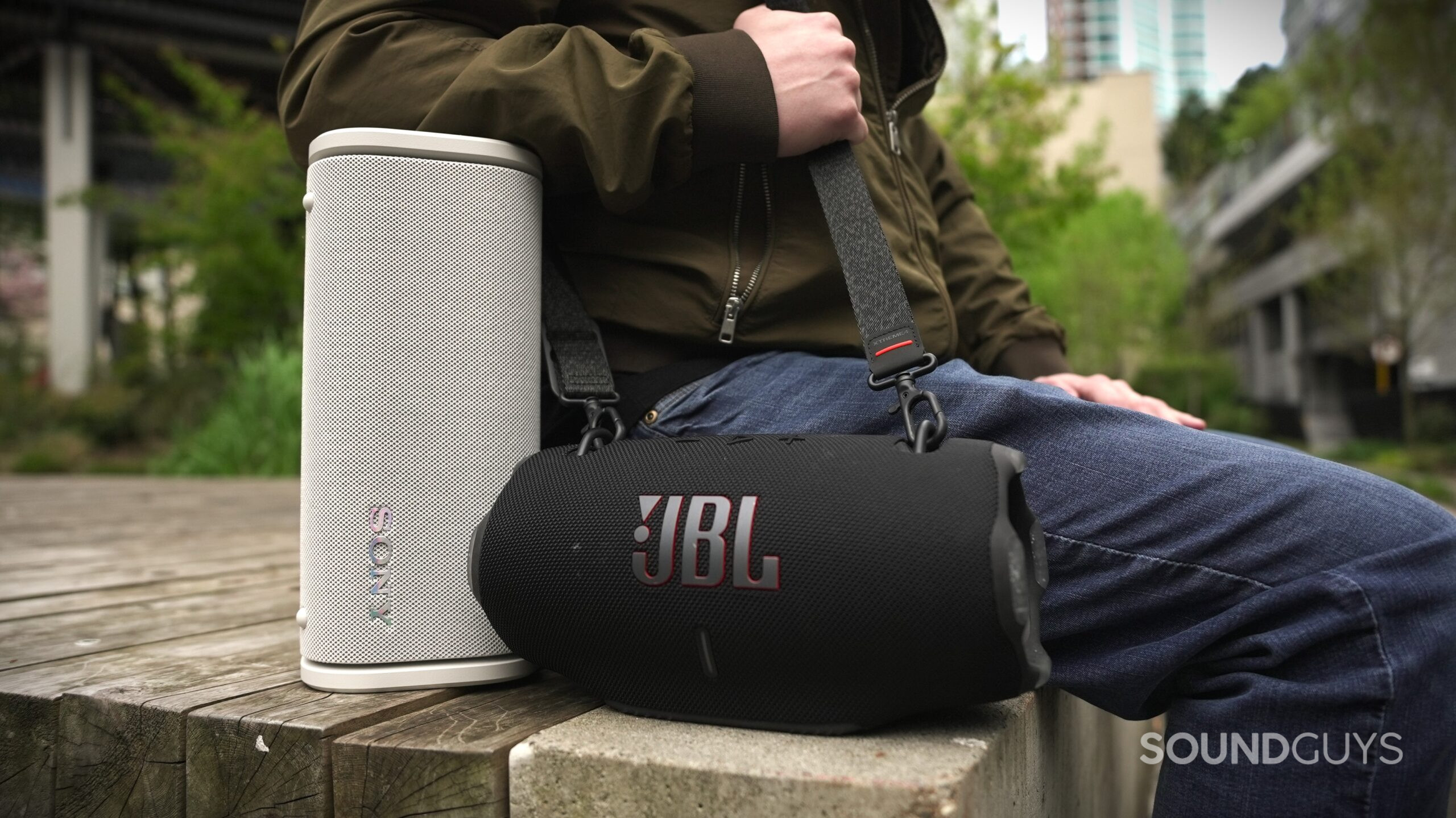 a man sitting with the sony ult field 5 and jbl xtreme 4 speakers a man sitting with the sony ult field 5 and jbl xtreme 4 speakers