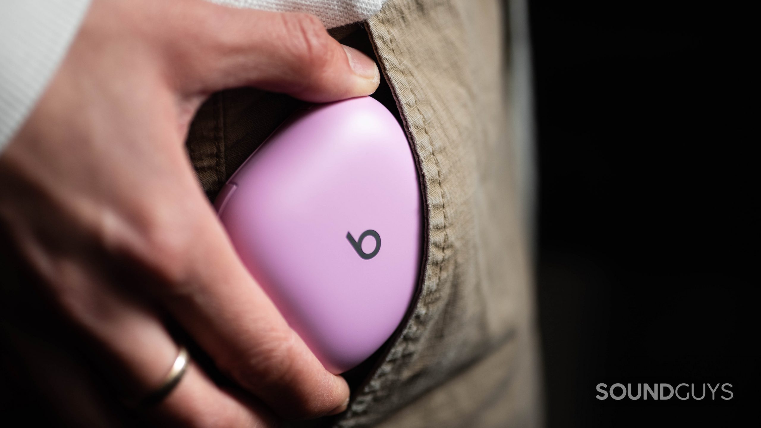 Beats Fit Pro noise canceling true wireless earbuds case pocket A woman's hand pockets the Beats Fit Pro noise canceling true wireless earbuds case which is in the color purple.