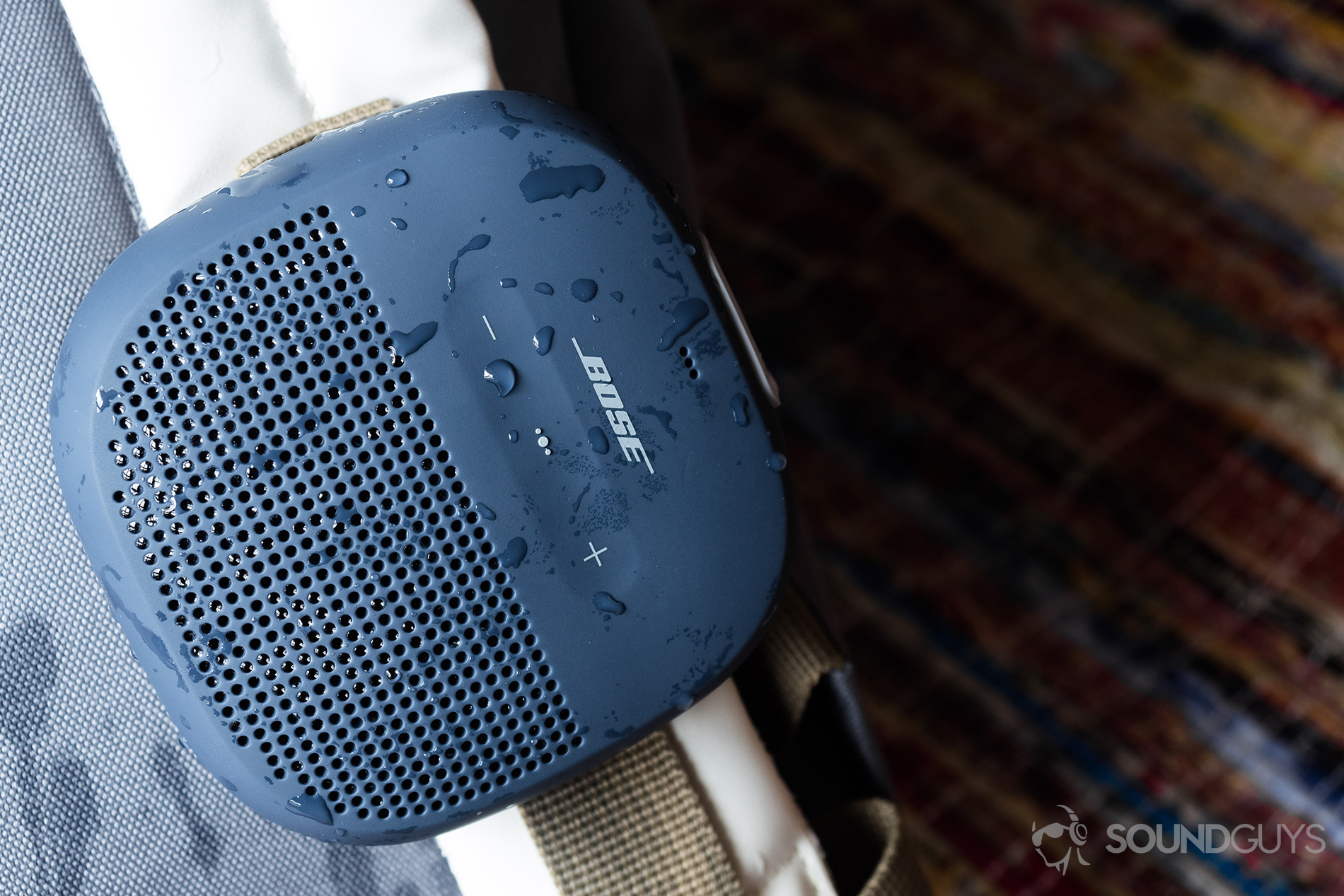 Bose_SoundLink Micro_ (1) The Bose SoundLink Micro (blue) hooked onto a white backpack.