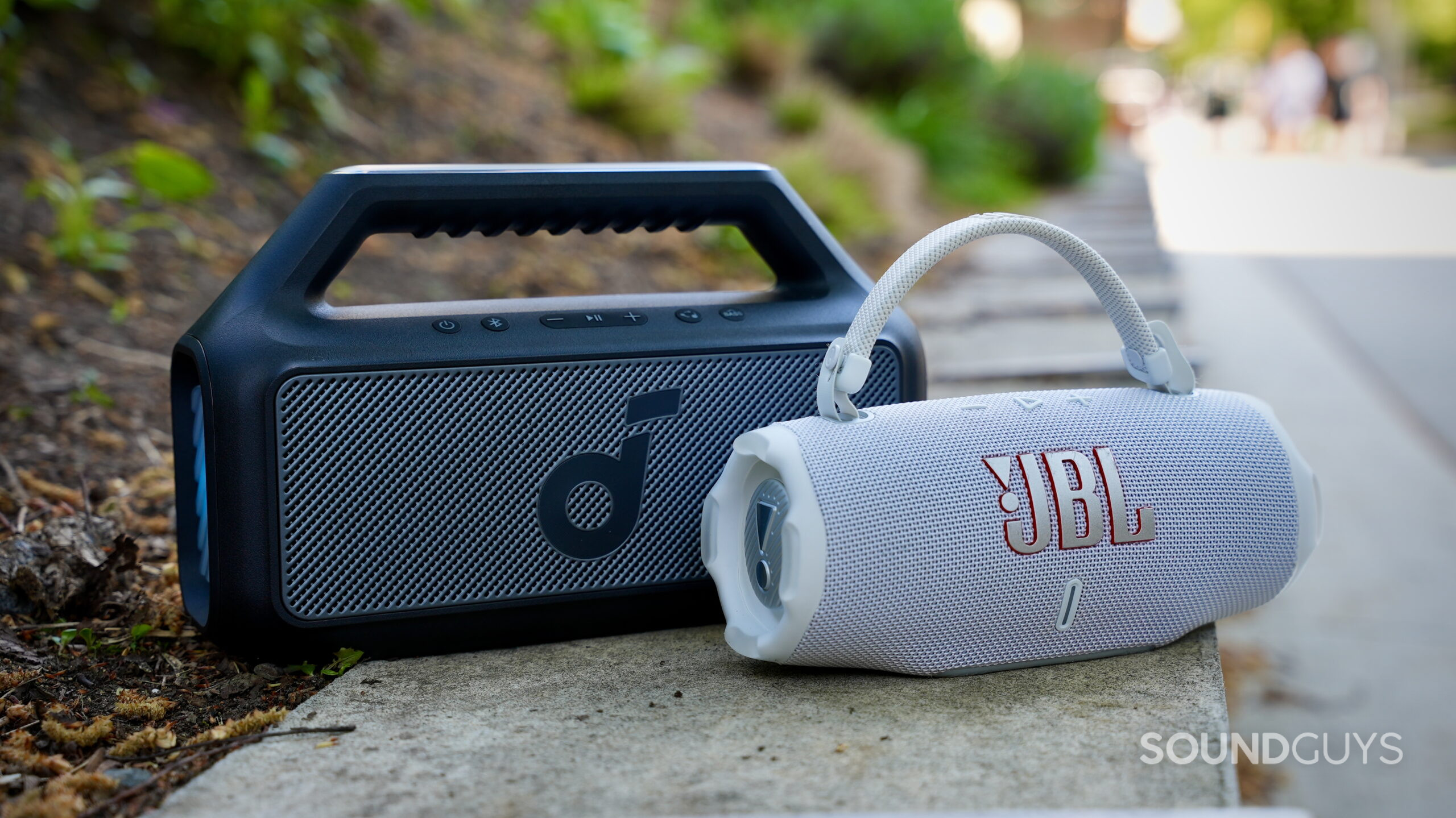 Charge 6 vs Boom 2 - 6 A Soundcore Boom 2 and a JBL Charge 6 sitting beside each other outside.