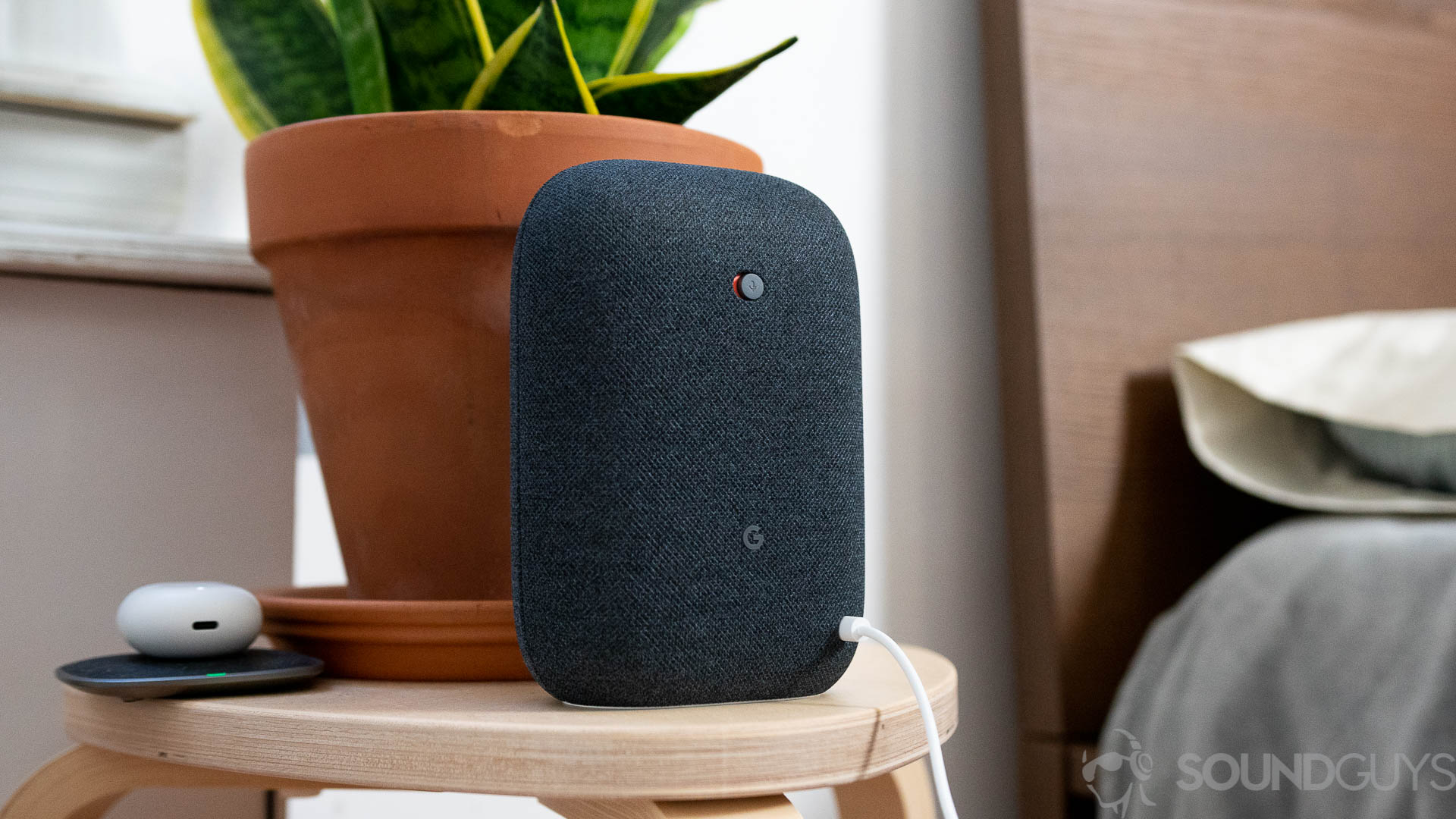 Google Nest Audio mute switch Google Nest Audio in black on nightstand next to bed