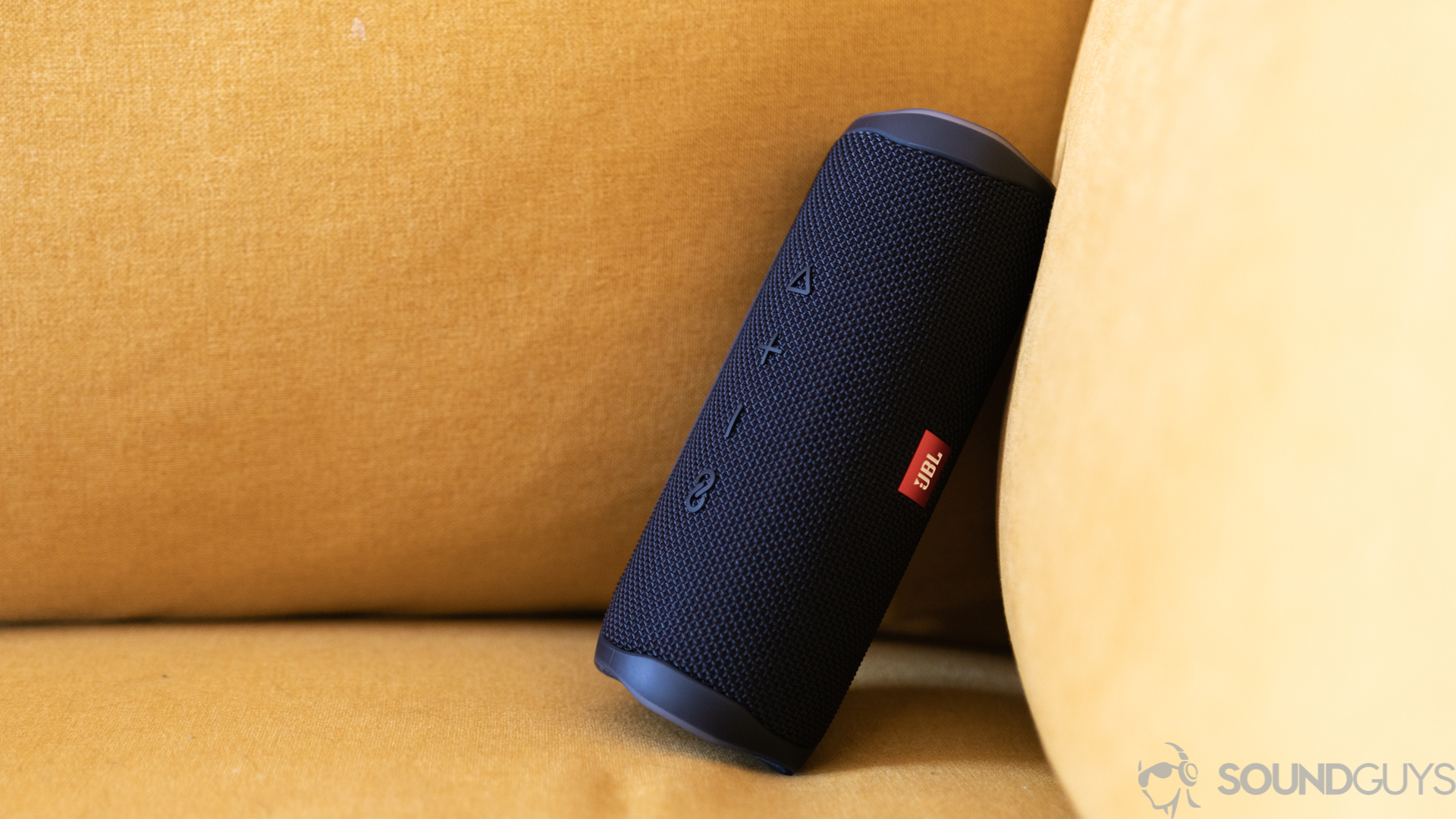 JBL Flip 5 on couch The JBL Flip 5 leaning on a yellow couch