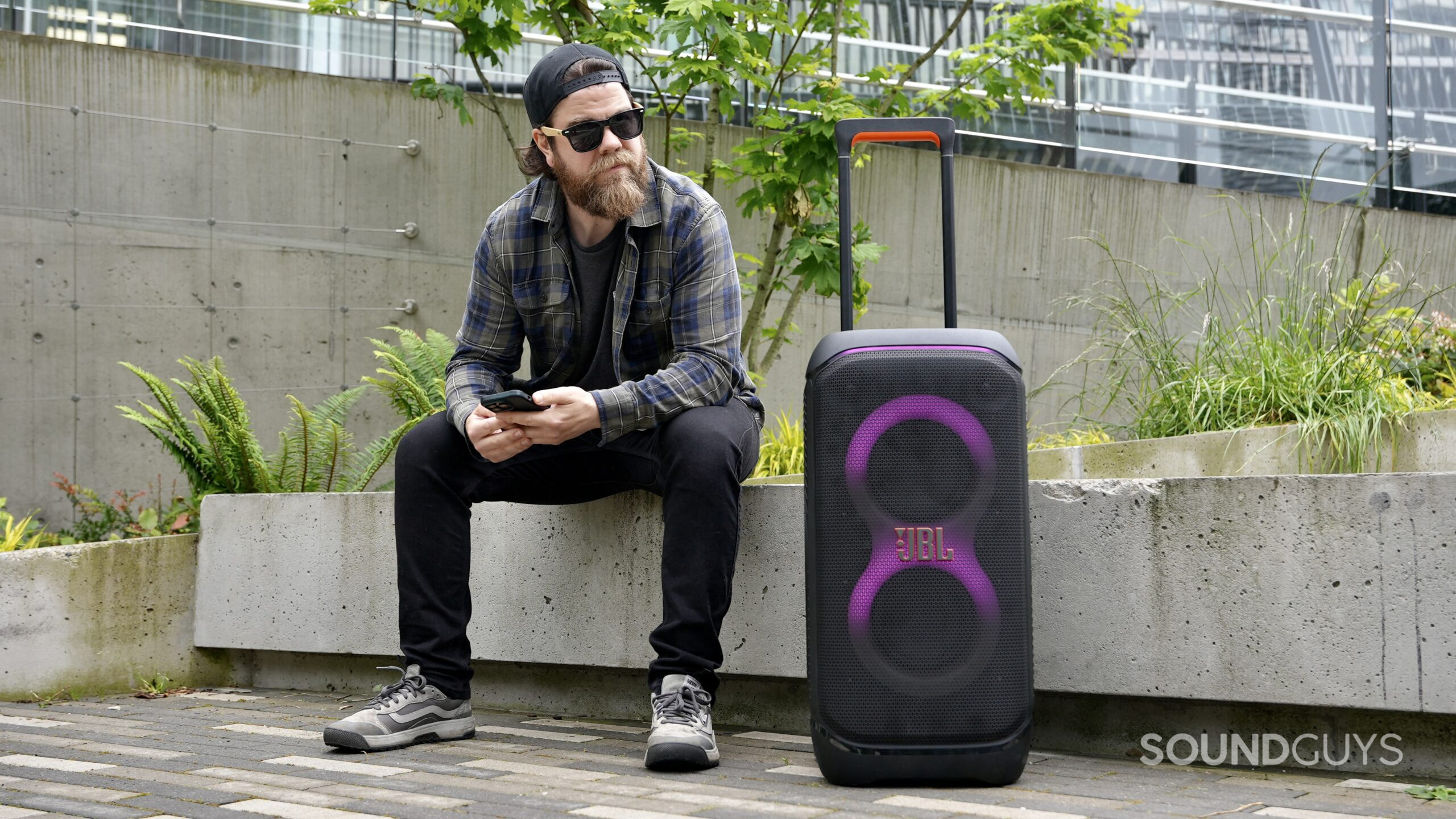 JBL PartyBox 320_1 A man sitting beside the JBL PartyBox 320 speaker