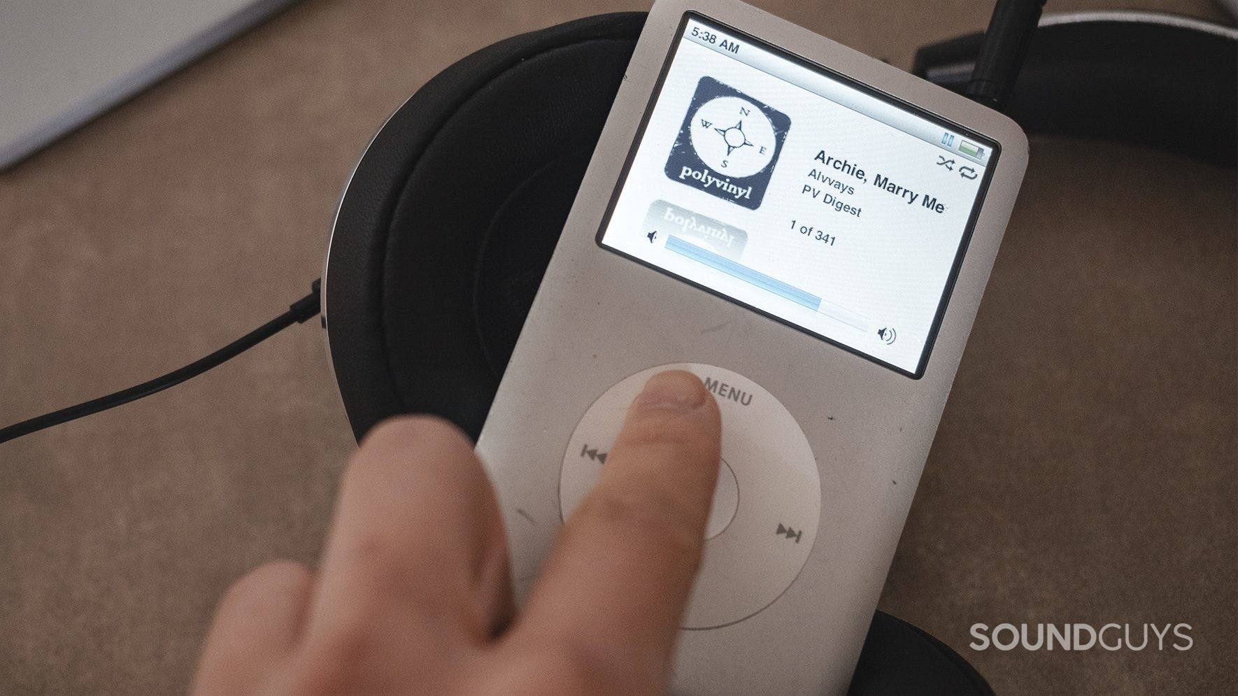 NIHL_LK A finger turning up the volume on an iPod Classic (silver).