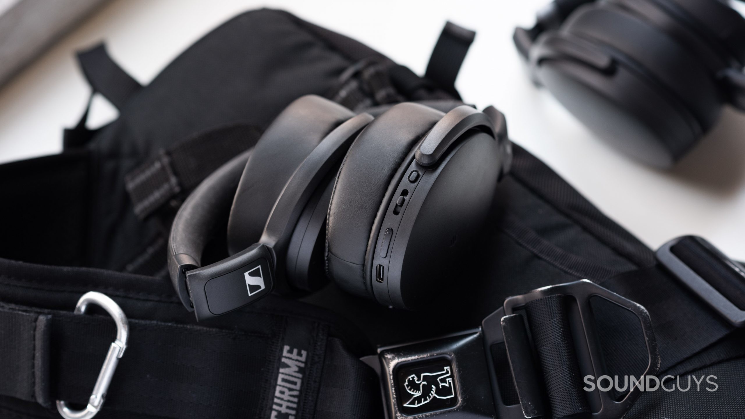 Sennheiser HD 350BT_fold ear cups hinges The Sennheiser HD 350BT Bluetooth headphones folded on top of a Chrome sling bag with the Sennheiser HD 450BT in the background.